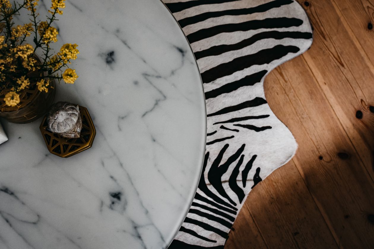 Zebra print rug beside a marble coffee table