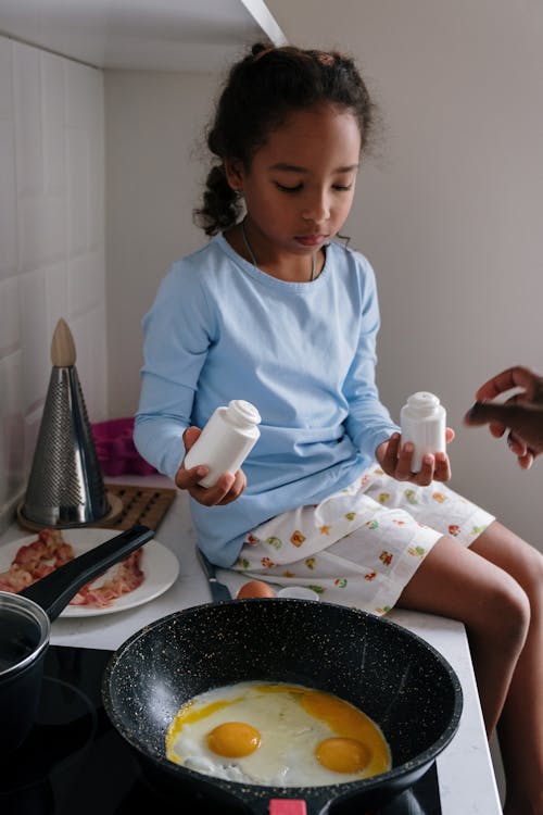 A Girl Cooking Eggs in the Kitchen