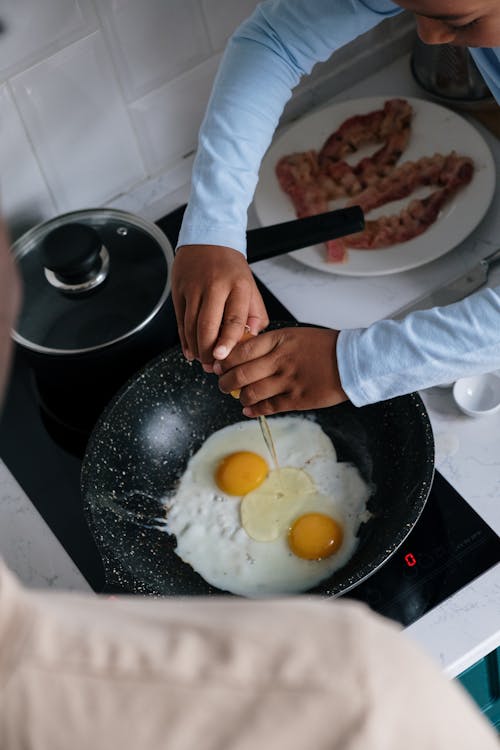 Free A Kid Cooking Eggs Stock Photo