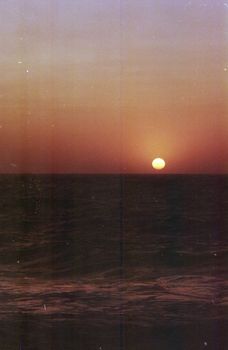 A peaceful sunset over the ocean in Corsica, with golden skies reflecting on the water.