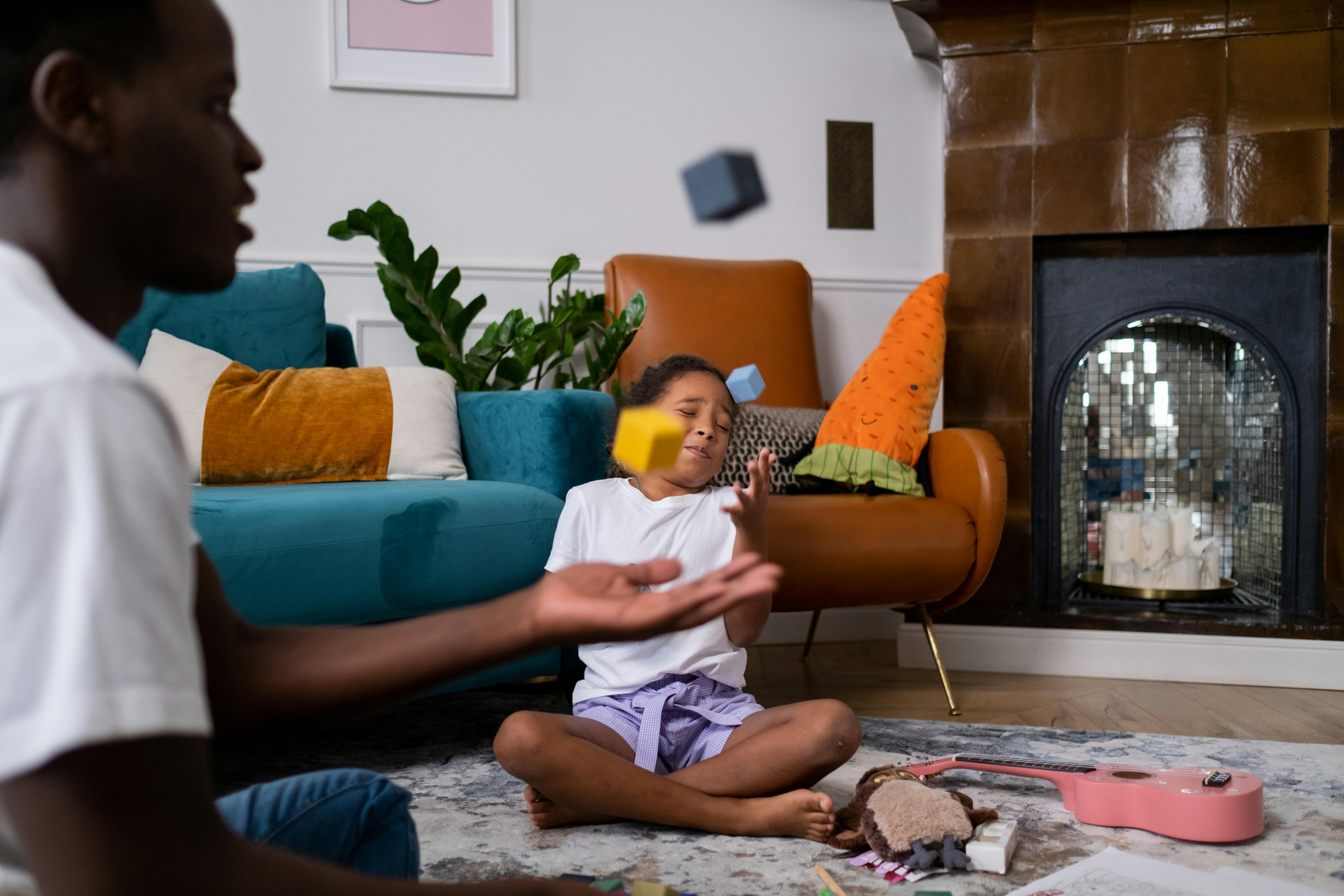 A father and daughter enjoy playing with toys in a cozy living room setting.