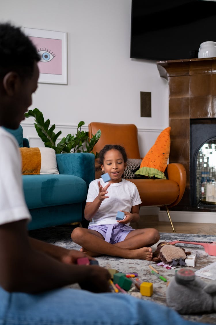 Father And Daughter Playing While Sitting On The Floor