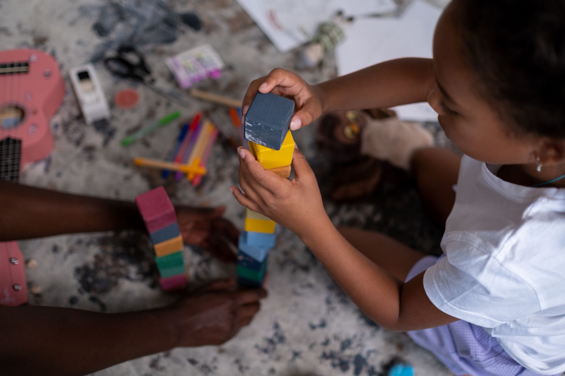 A Girl Piling Cube Blocks