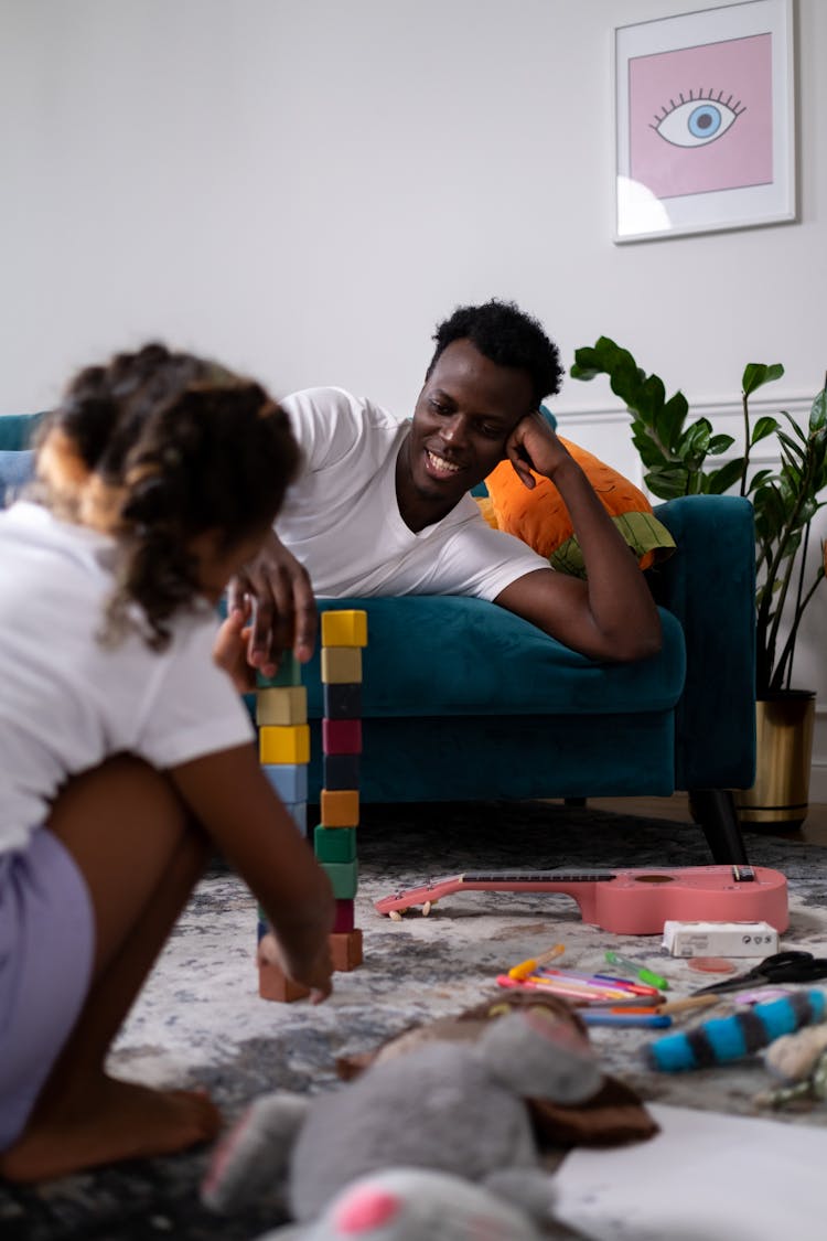 Father And Daughter Playing While Sitting On The Floor