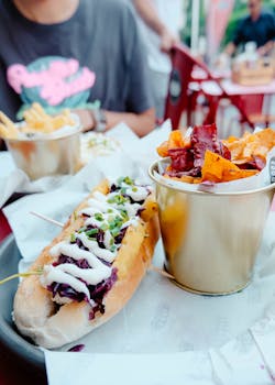 A vibrant hot dog with sauces and a side of chips, perfect for casual dining.
