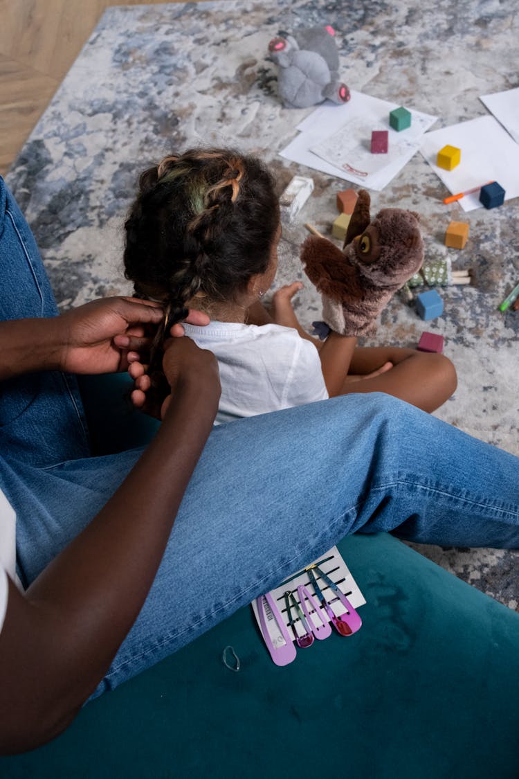 Person Braiding Hair Of The Girl