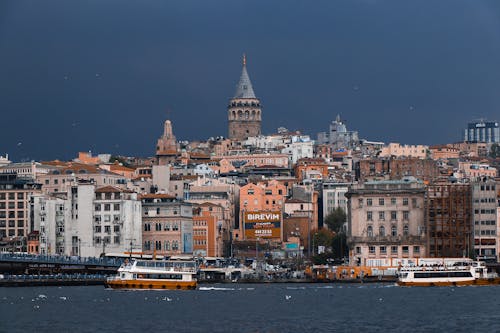 Brown and White Concrete Buildings Near Body of Water