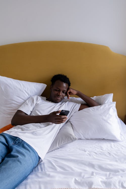 Man in White Shirt Lying on Bed