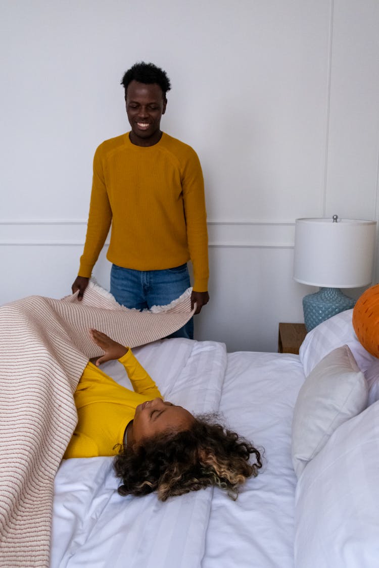 A Father Tucking Daughter In Bed