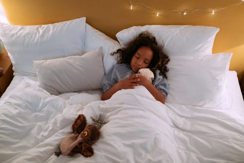 Free Girl Hugging a Stuff Toy While Sleeping  Stock Photo