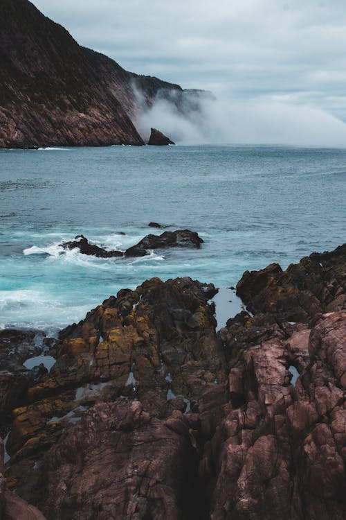 Rough mountains and rippled sea in foggy weather