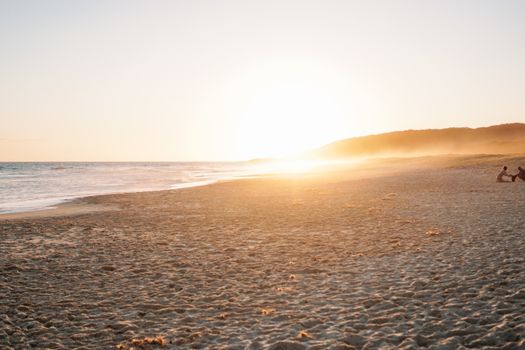 A picturesque beach sunset scene with a golden horizon, waves, and serene atmosphere.