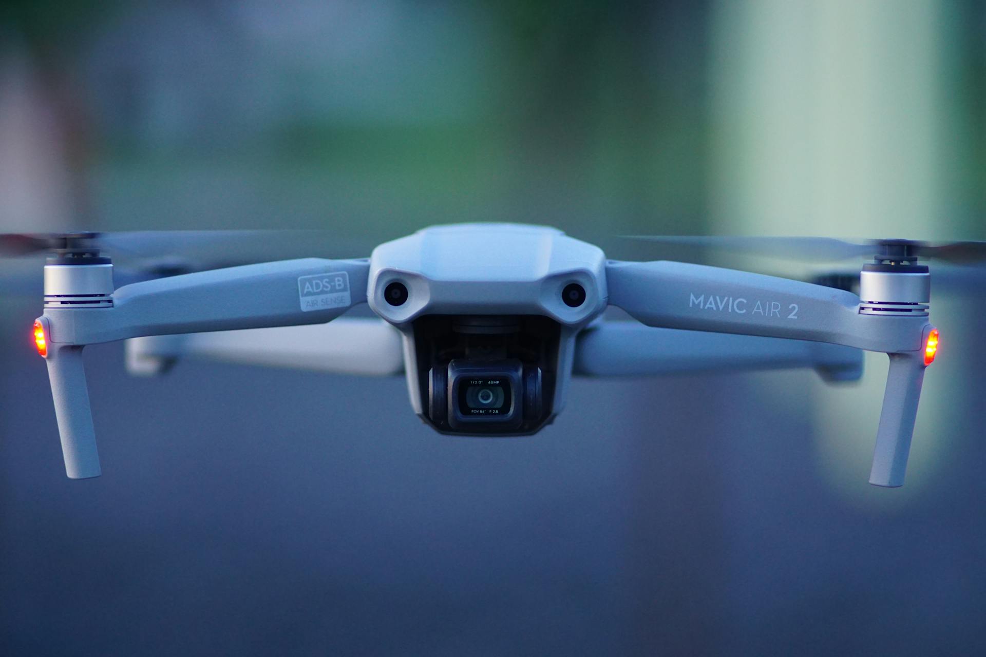 Close-up shot of Mavic Air 2 drone with propellers spinning, blurred background.