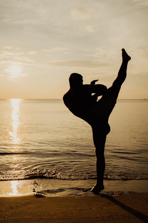 Silhouette of Man Practicing Kickboxing on the Seashore During Sunset ...