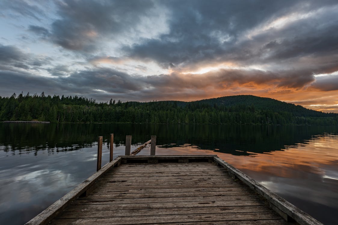 Brown Wooden Dock on Lake Under the Cloudy Sky