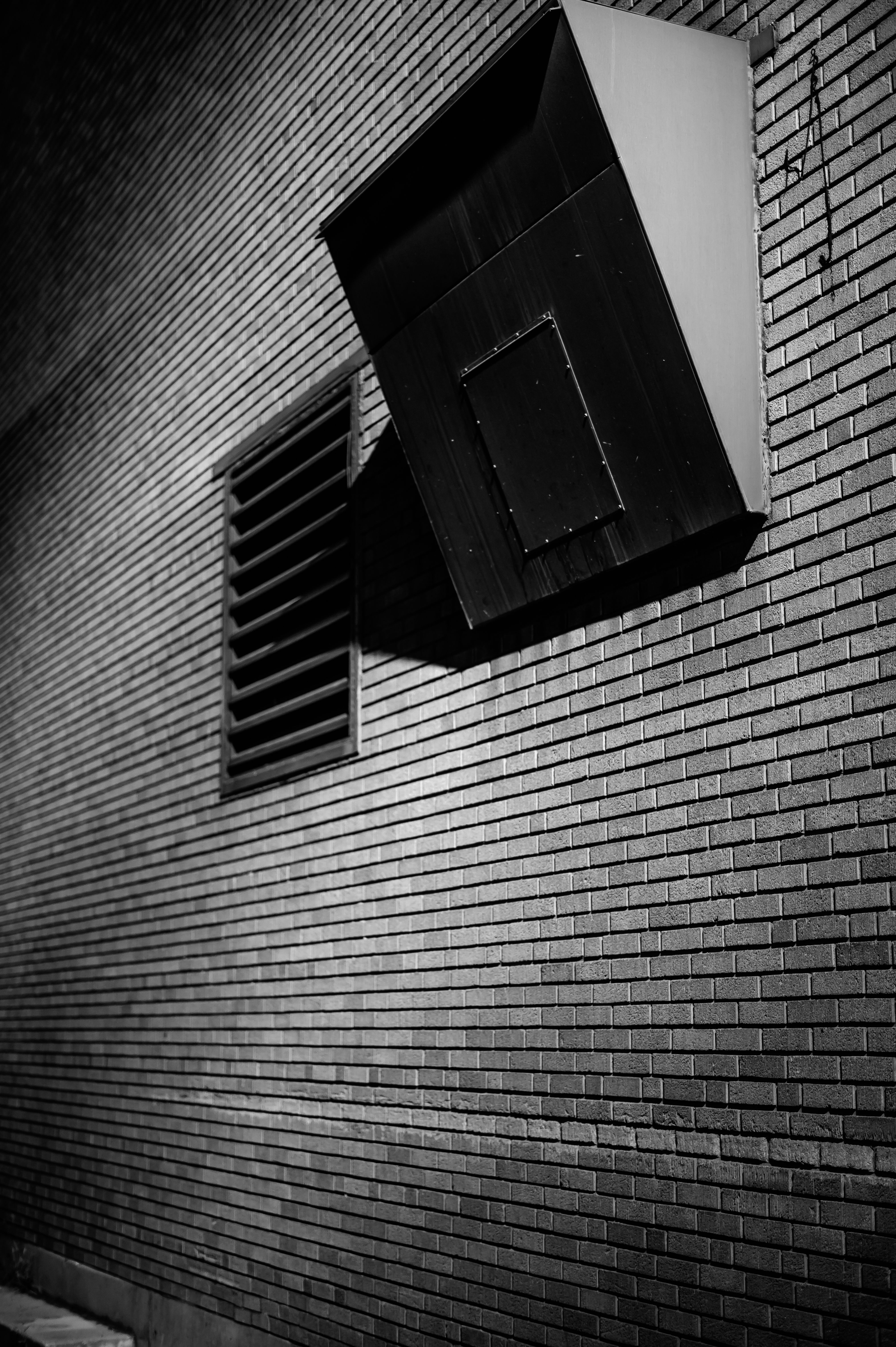 Row of white plastic louvre vents fitted into an external brick wall for underfloor ventilation