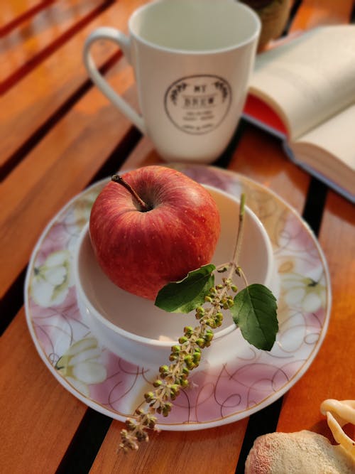 Free Red Apple on White and Pink Floral Ceramic Plate Stock Photo