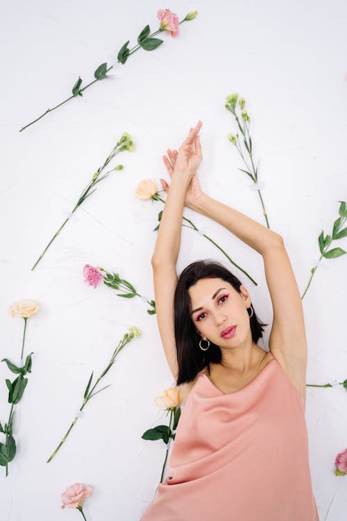 Gratis lagerfoto af arme hævet, blomster, kigger på kameraet