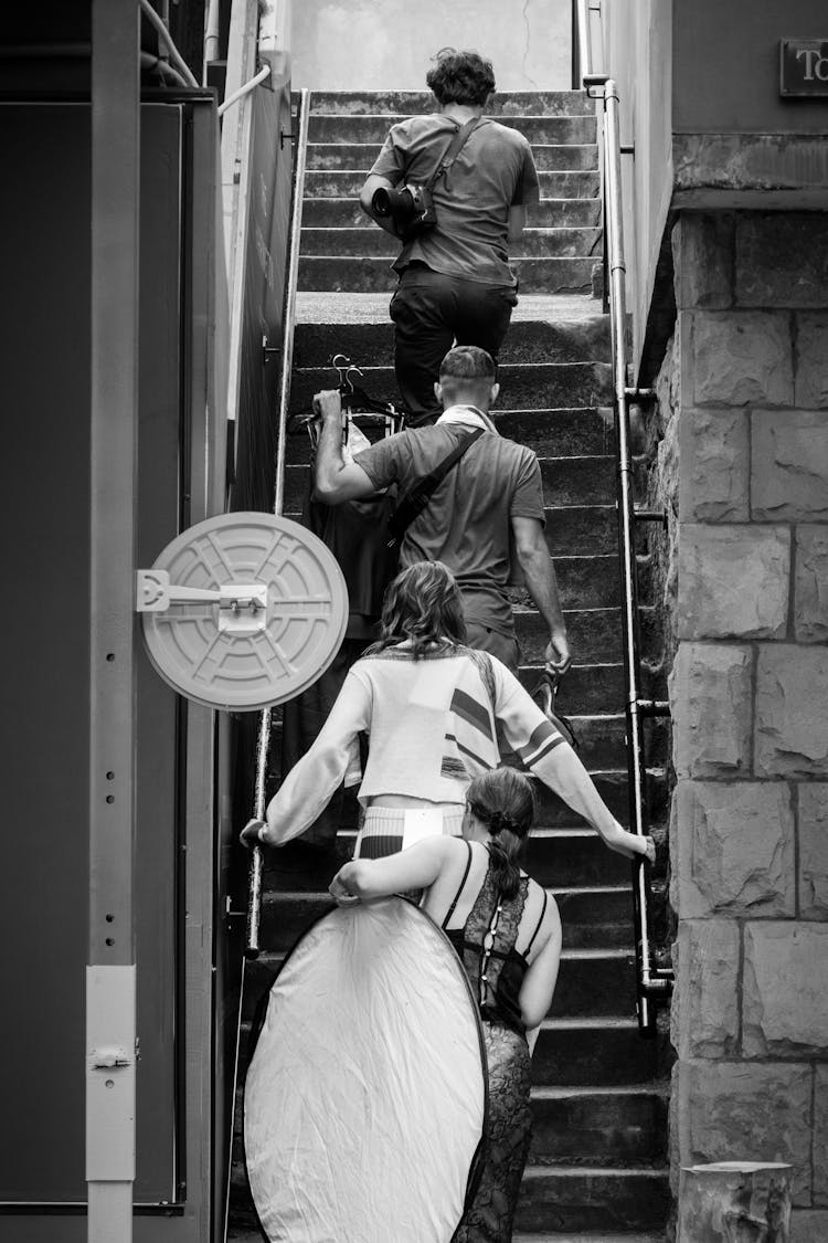 Grayscale Photo Of People Walking Up Stairs