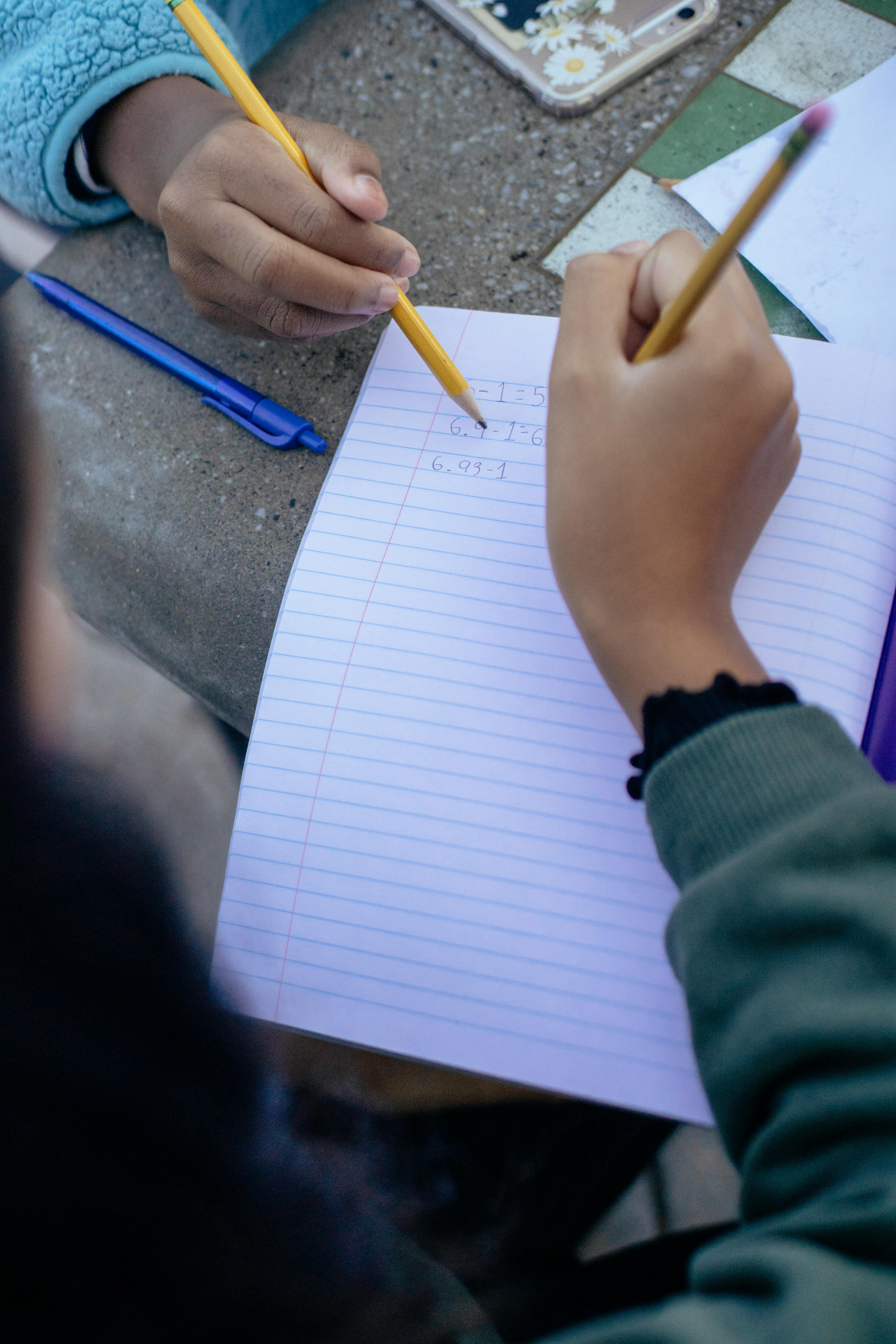 crop little girl doing homework with friend