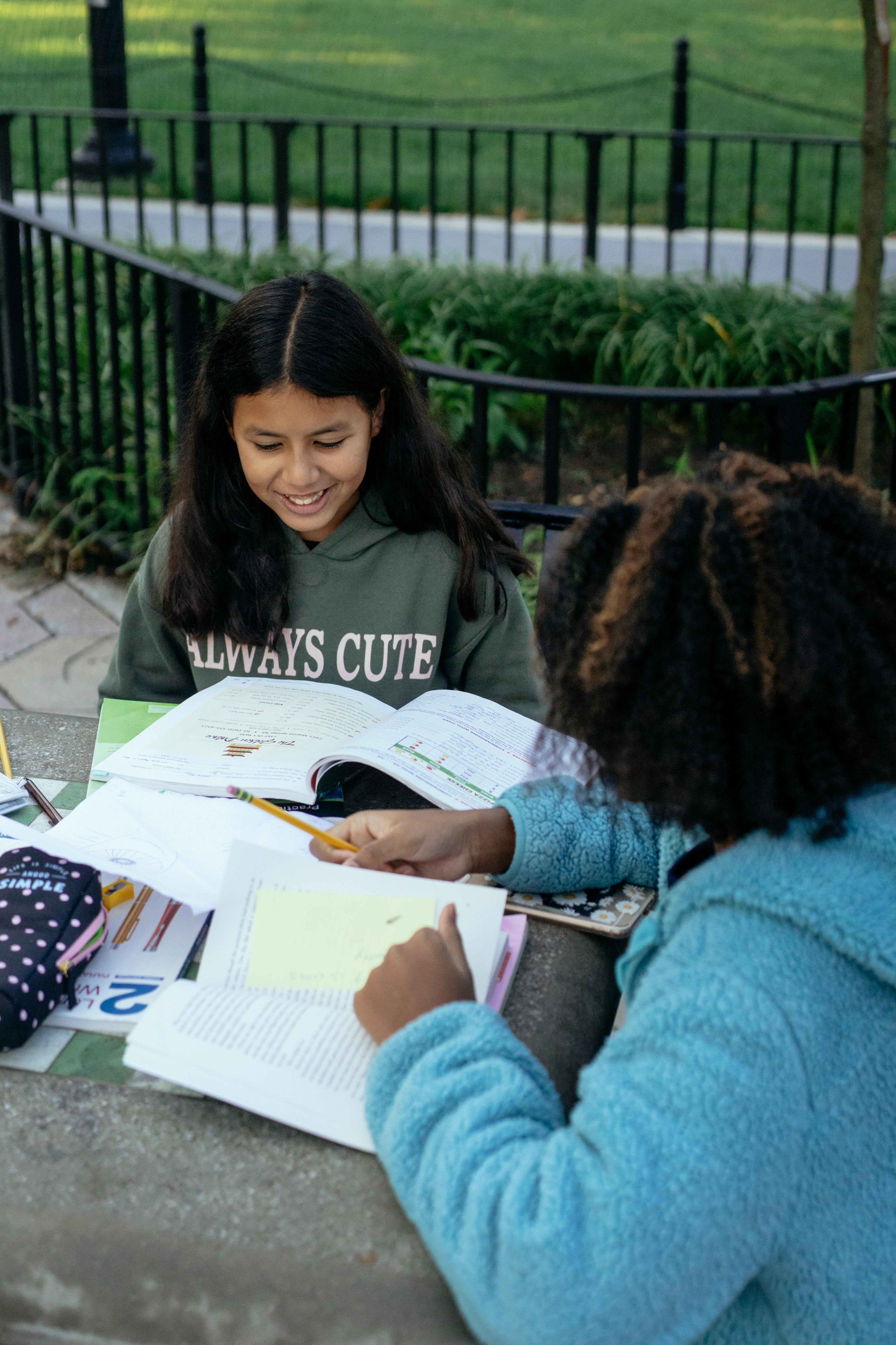 little hispanic girl studying with friend