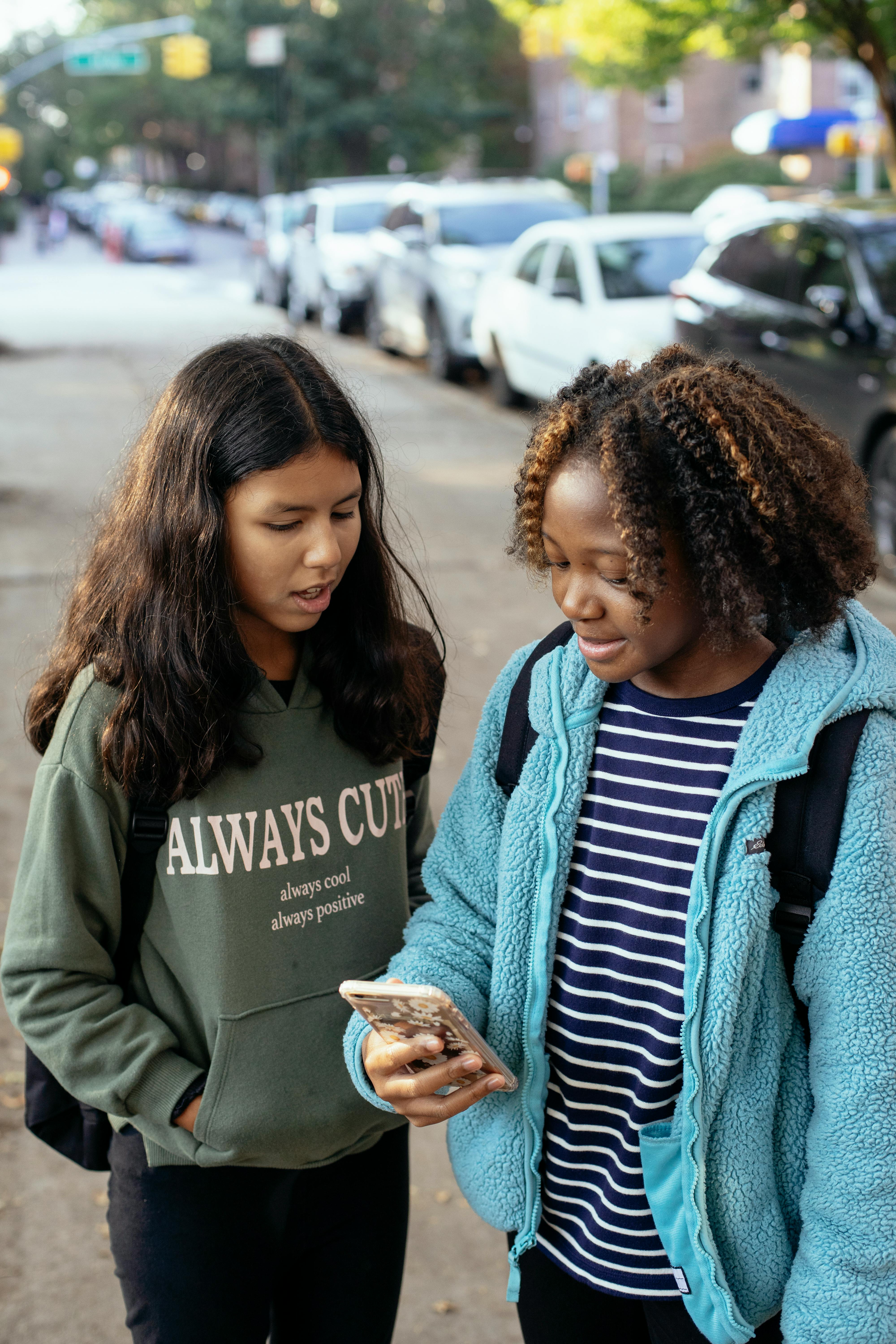 multiethnic classmates chatting on smartphone together