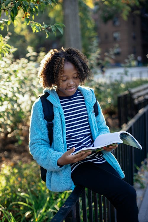 黑人小姑娘在公園裡讀書教科書