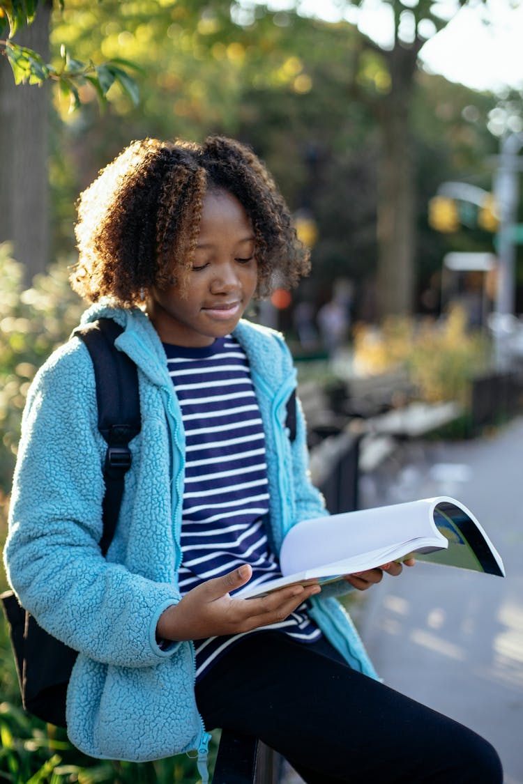 Black Schoolgirl With Workbook Studying On Street