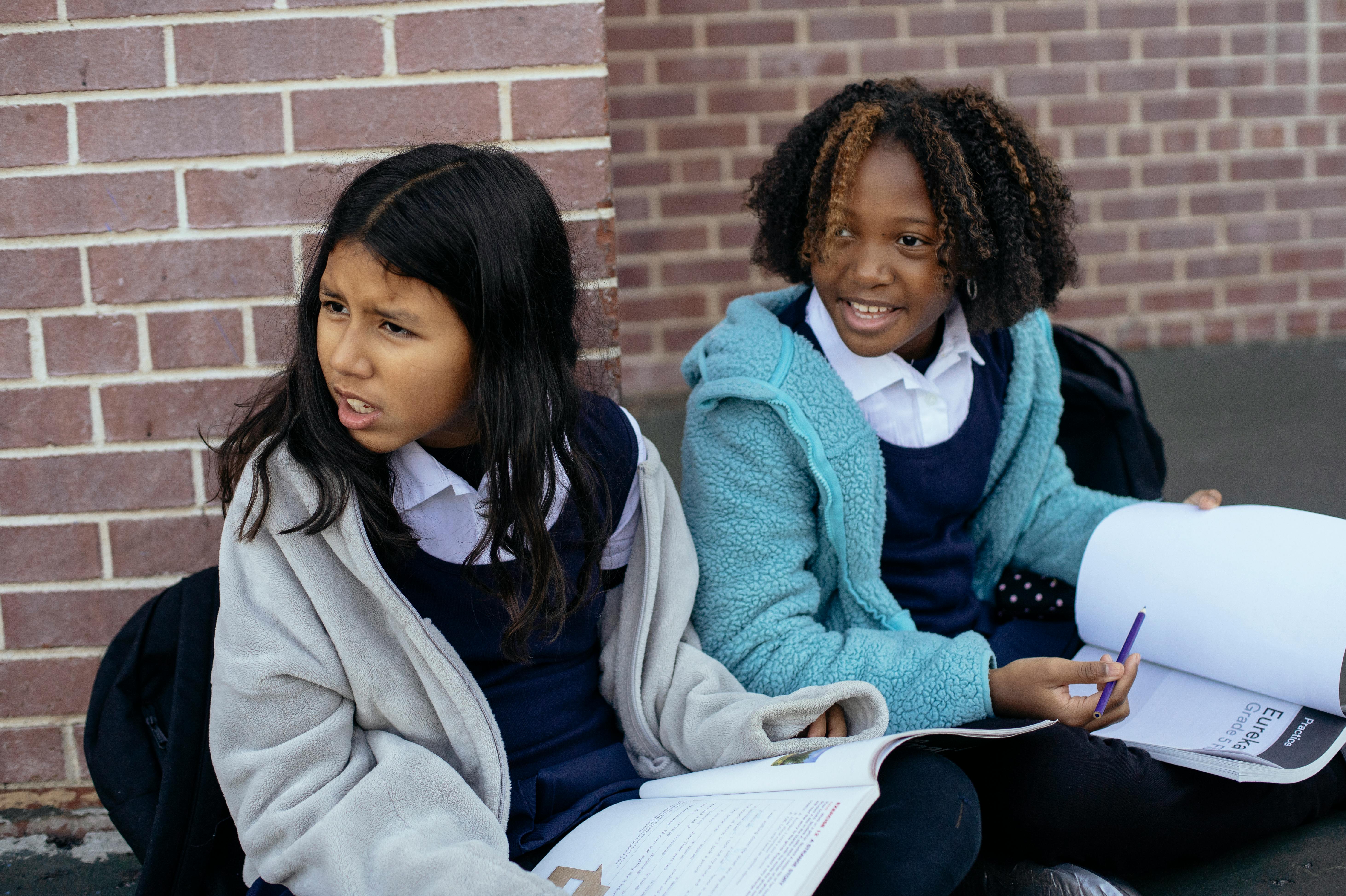 multiethnic children with textbooks looking away with excitement