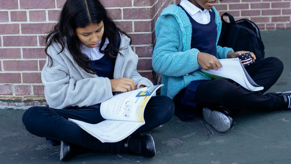 一緒に教科書を調べる気配りのある多様な女の子