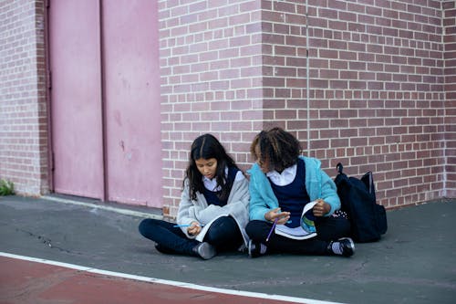 Ragazze Multietniche Che Parlano Della Scuola E Scrivono Nei Libri Di Testo