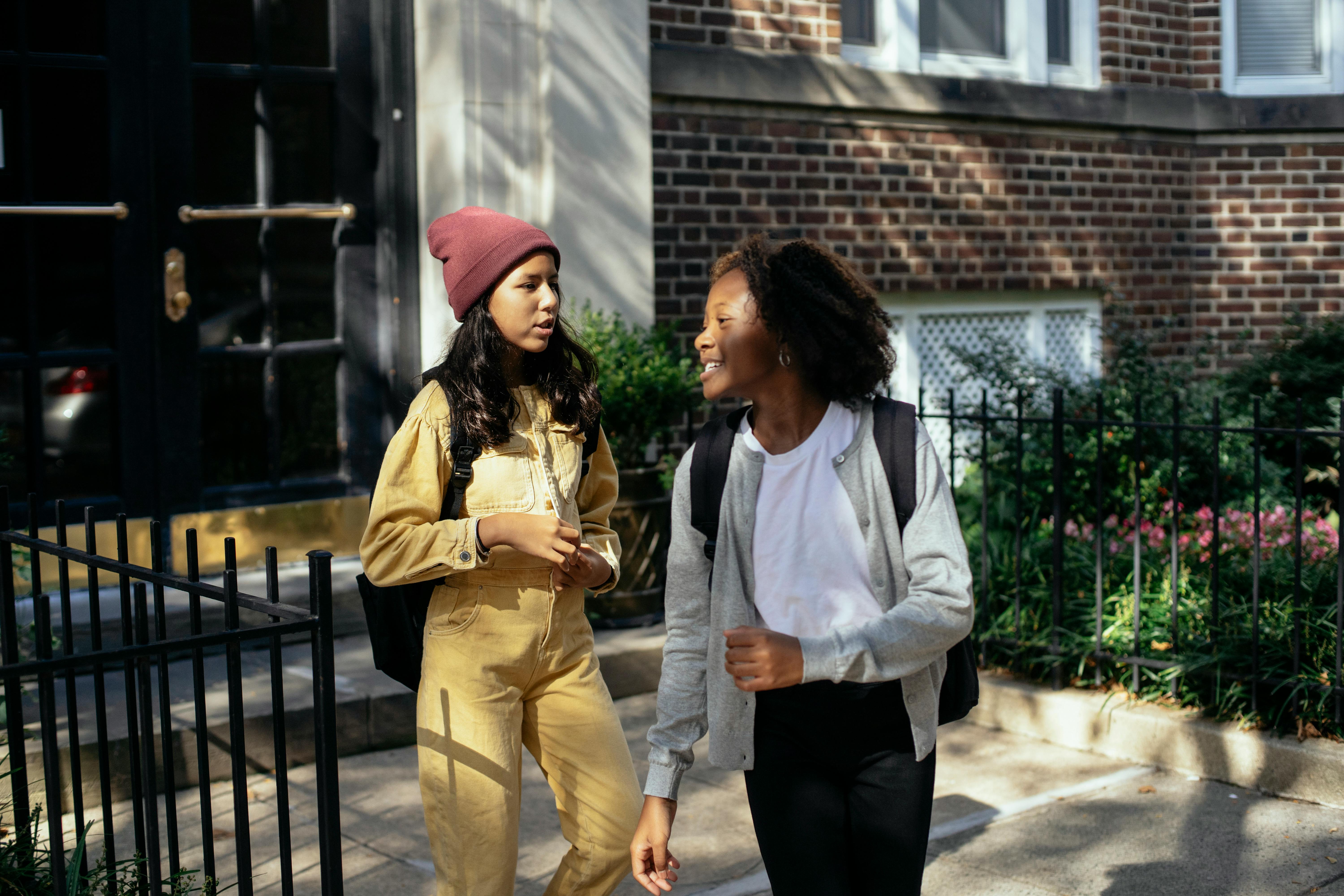 cheerful diverse girls talking on street