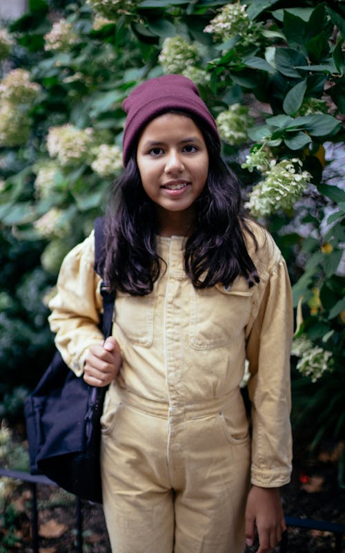 Free 微笑在盛開的布什附近的可愛的西班牙裔女孩 Stock Photo