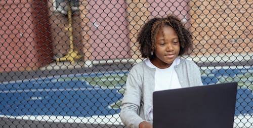 Glimlachend Zwart Meisje Kijken Naar Laptop Op Straat