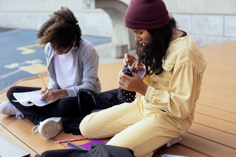 Crop Multiethnic Schoolkids With Pencil Box Studying On Street