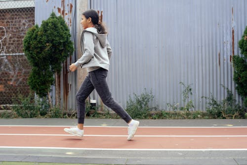 Ethnic girl running on empty stadium