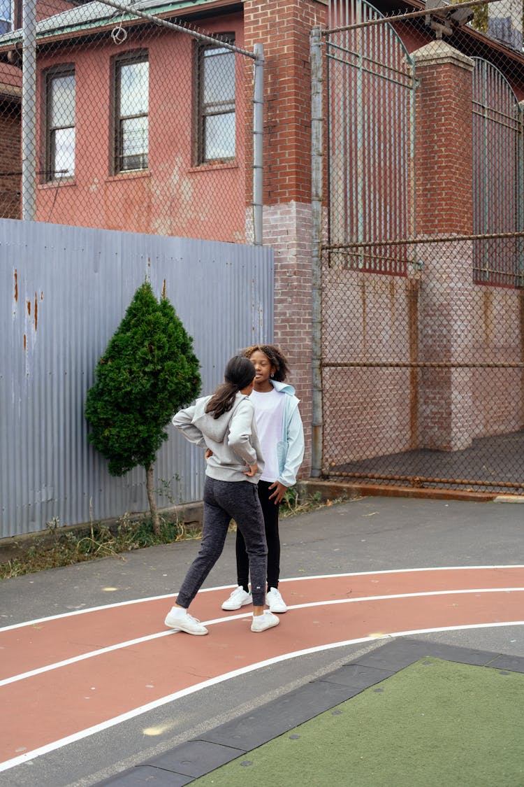 Diverse Girls Resting After Jog On Sports Ground