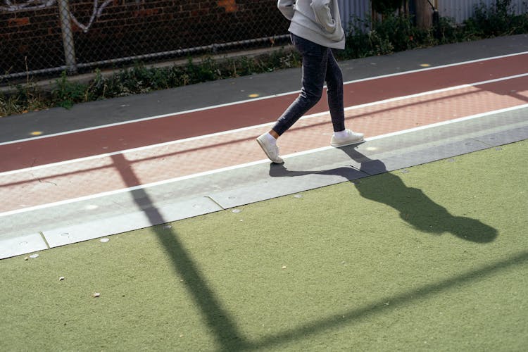 Crop Child Walking Fast On Stadium