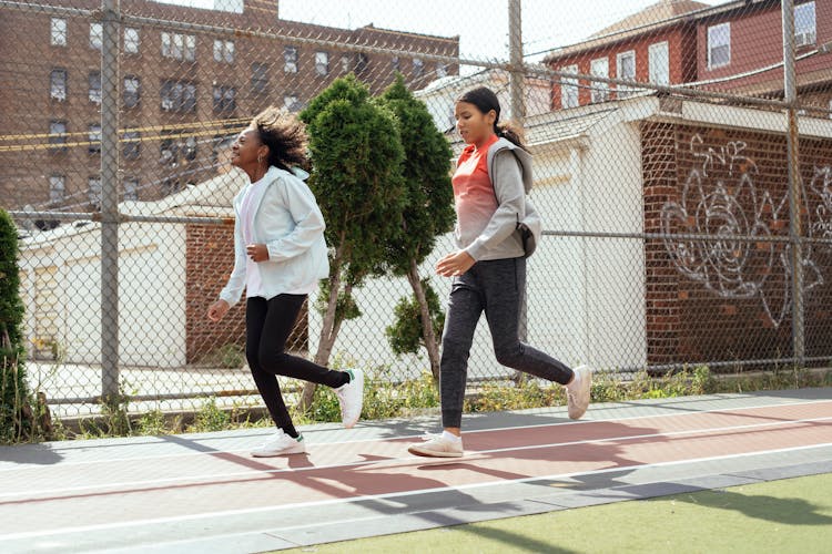 Diverse Schoolgirls Running On Stadium Together