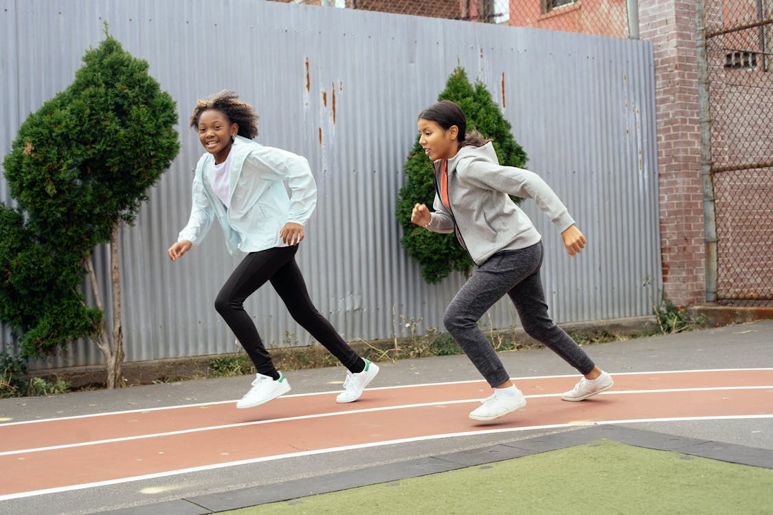 Meninas Multiétnicas Correndo Em Quadras Esportivas