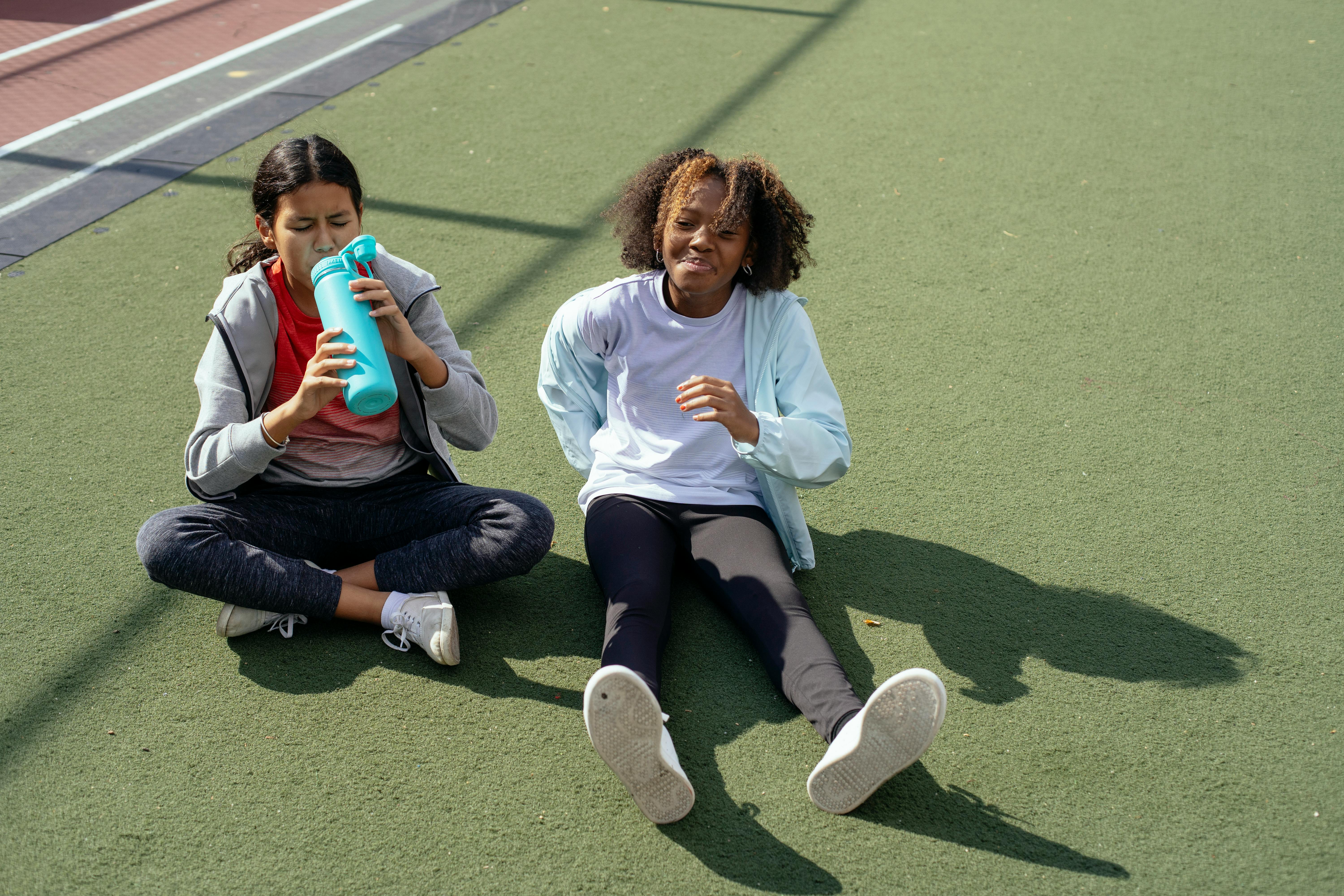 multiethnic girls resting on stadium after training