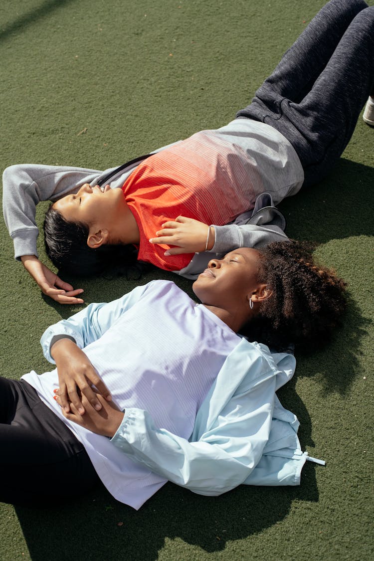 Diverse Schoolgirls Lying On Sports Ground