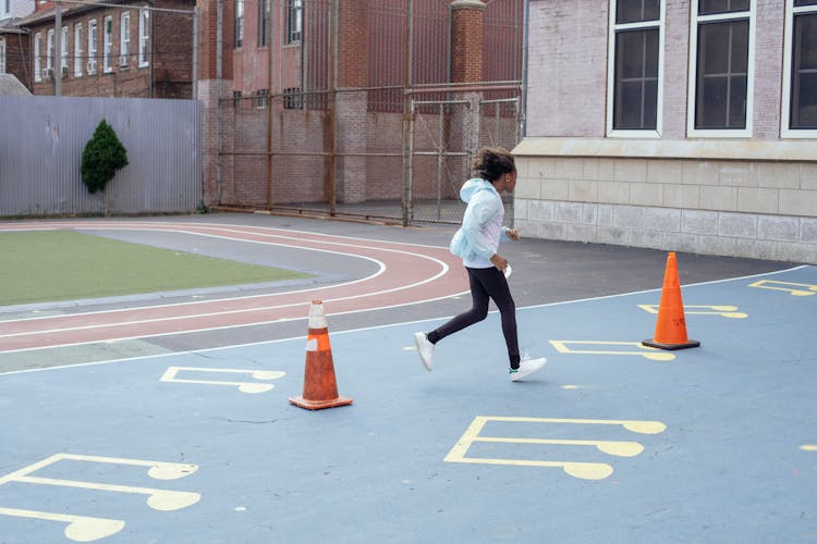 Active Sportive Girl Running Fast During Break On Playground Near School