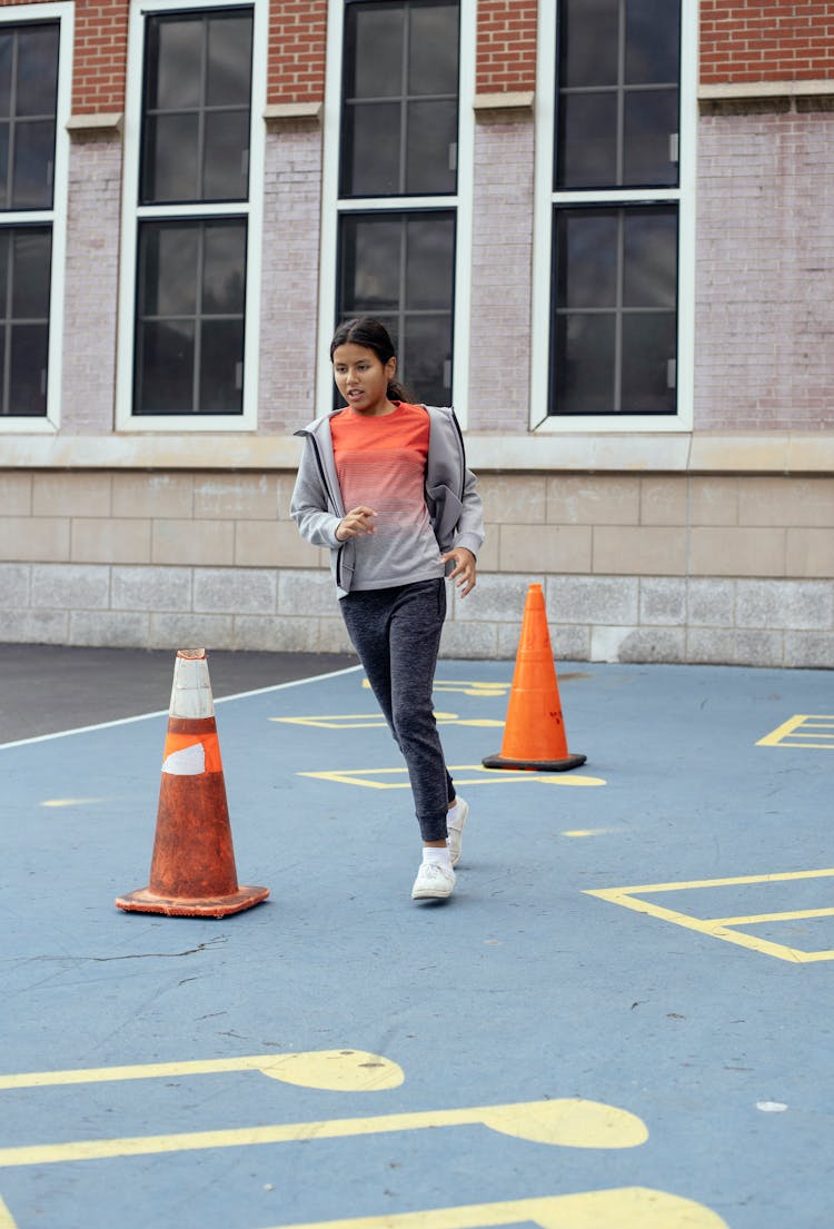 Schoolgirl Running In School Yard During Lesson