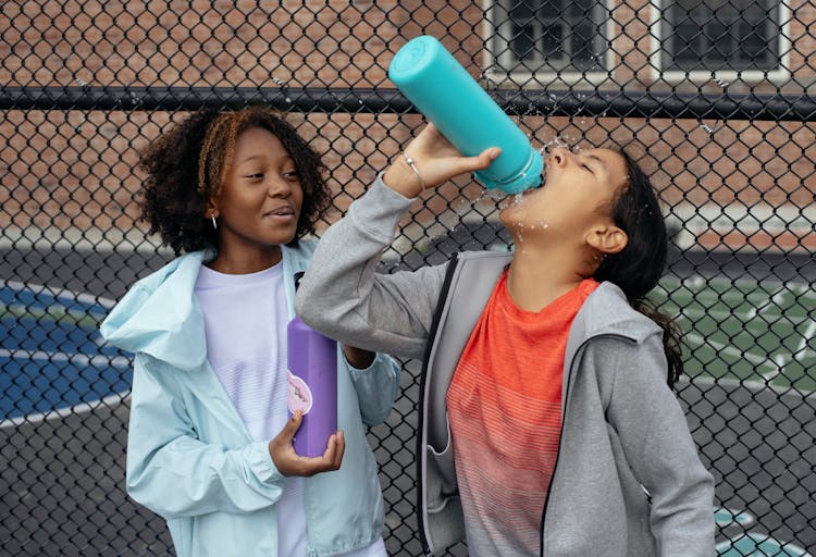 Tired Diverse Schoolgirls Drinking Water