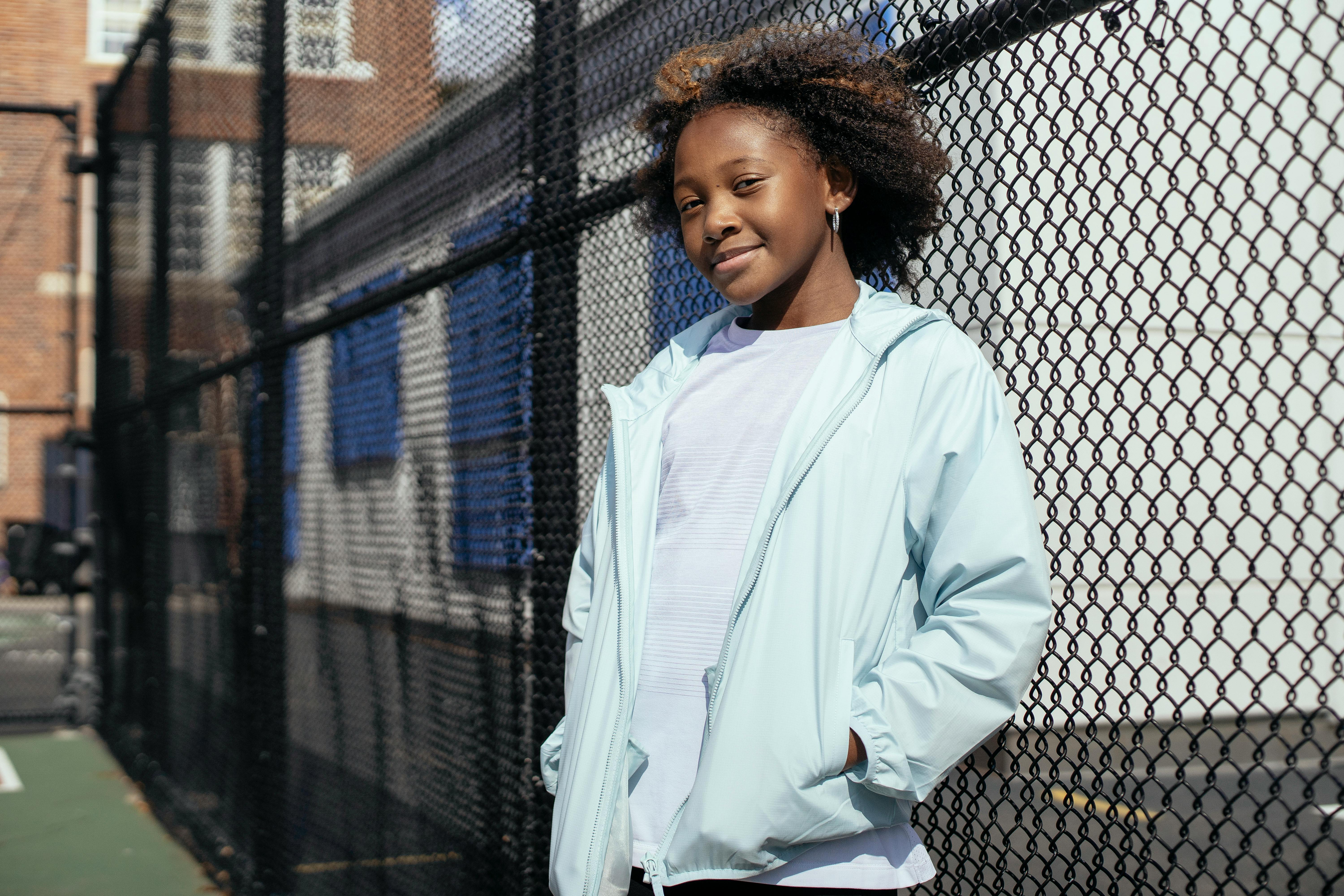 smiling ethnic girl neat metal fence