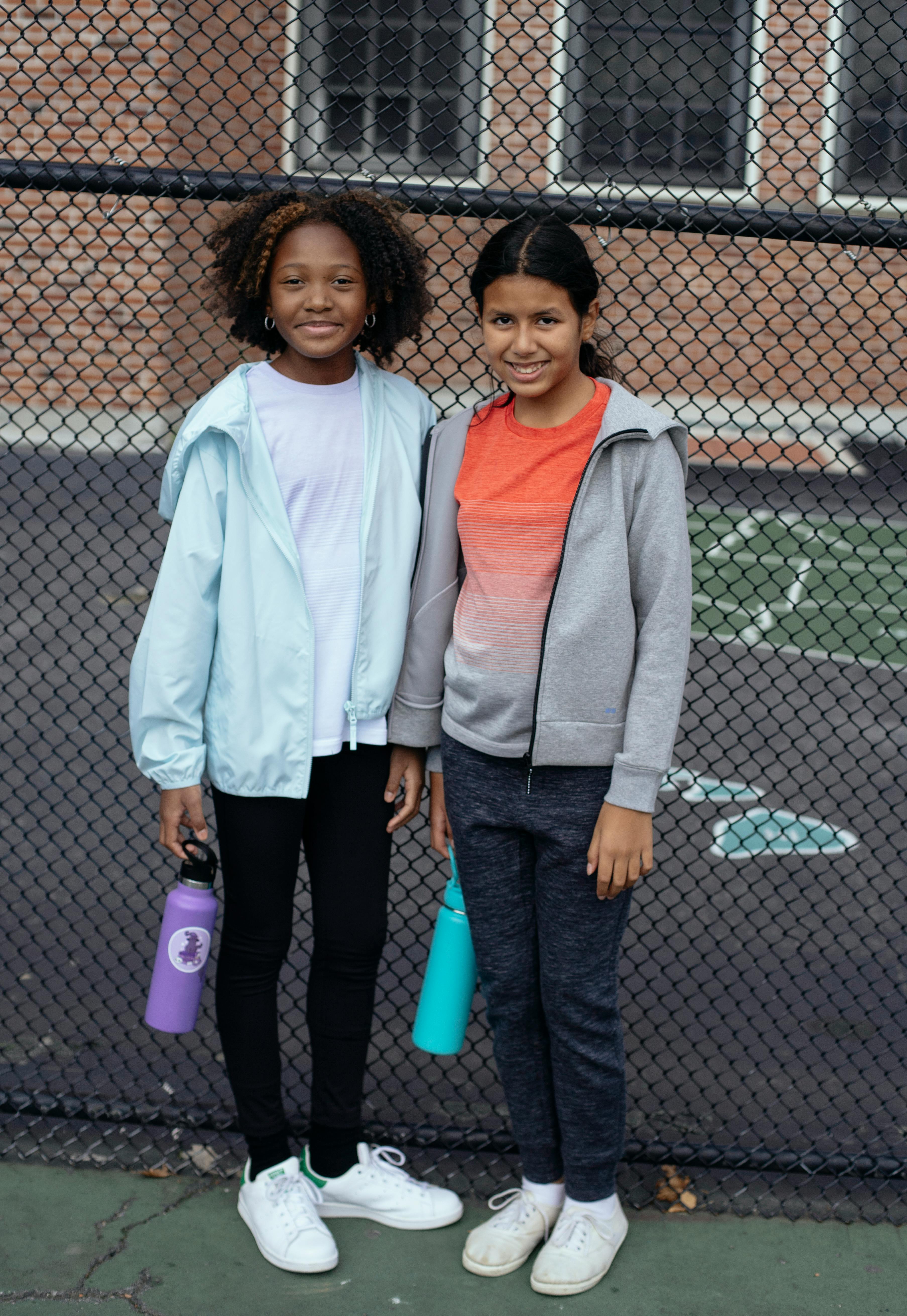 smiling diverse friends on sports ground