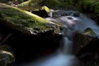 长时间拍摄一条宁静的溪流、布满苔藓的岩石和柔和的瀑布