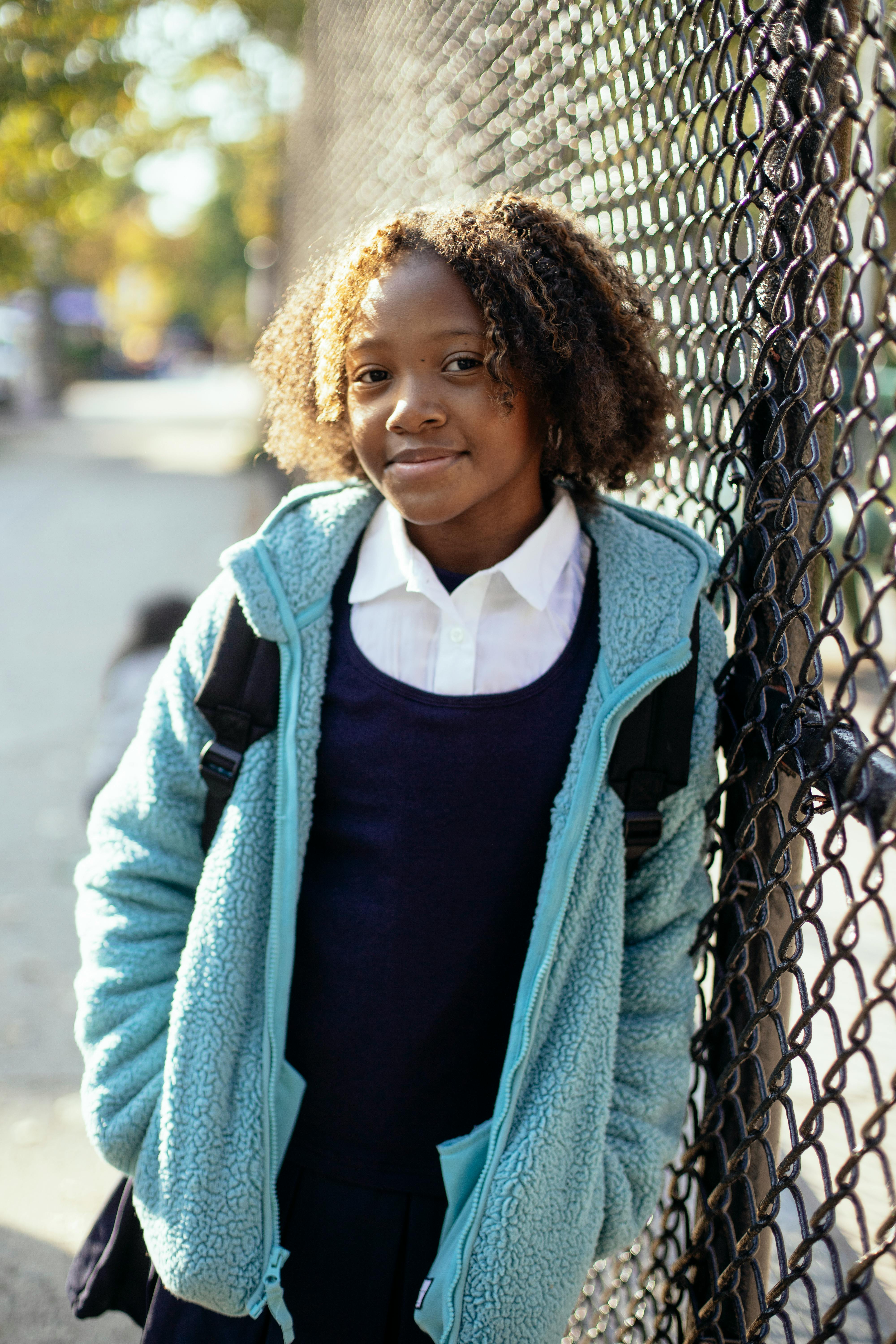 black girl near fence looking at camera