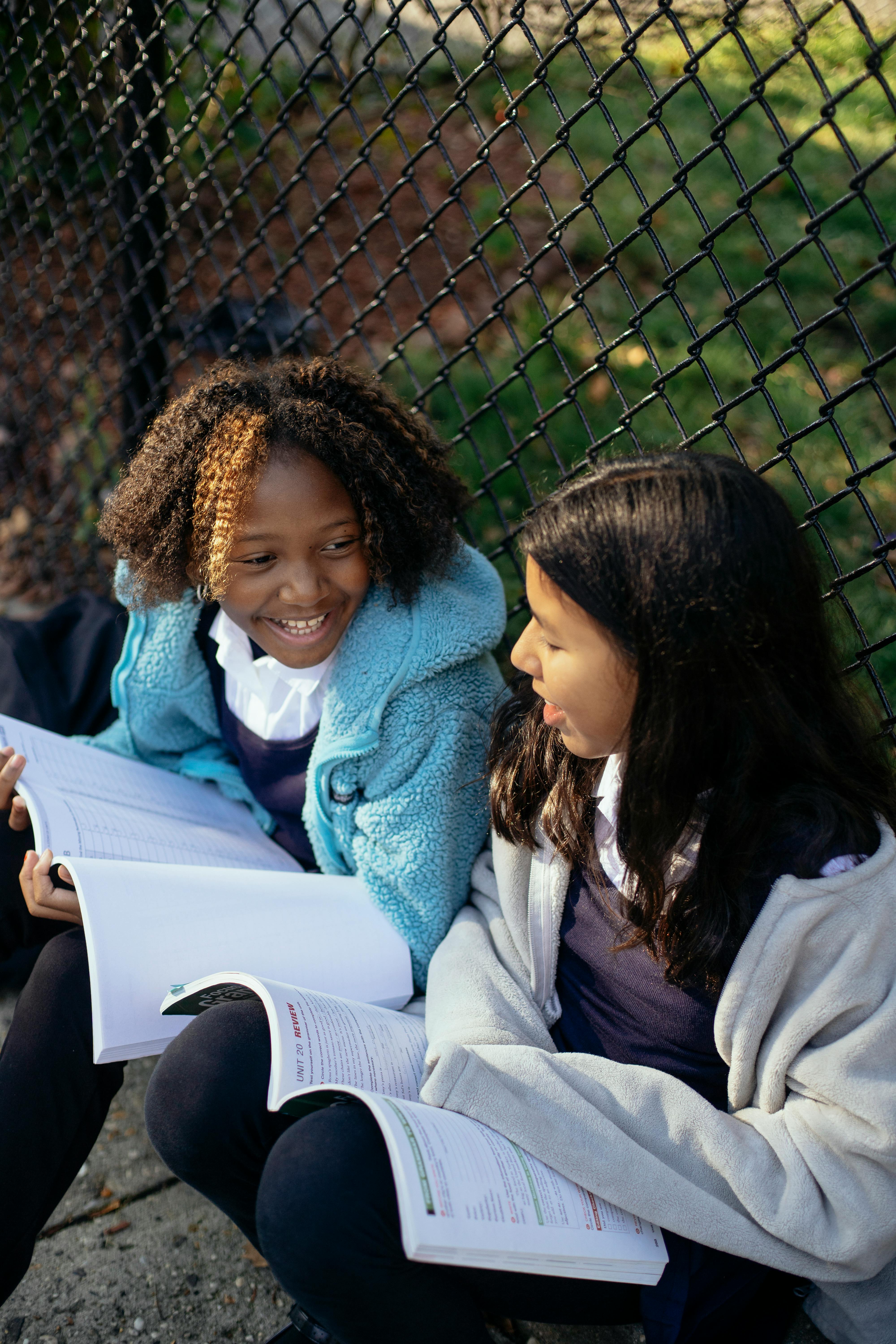 smiling multiethnic girls with copybooks